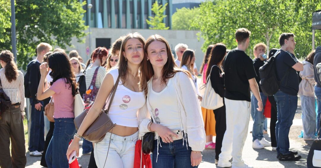 Zwei Frauen stehen zusammen in einer Menschenmenge.