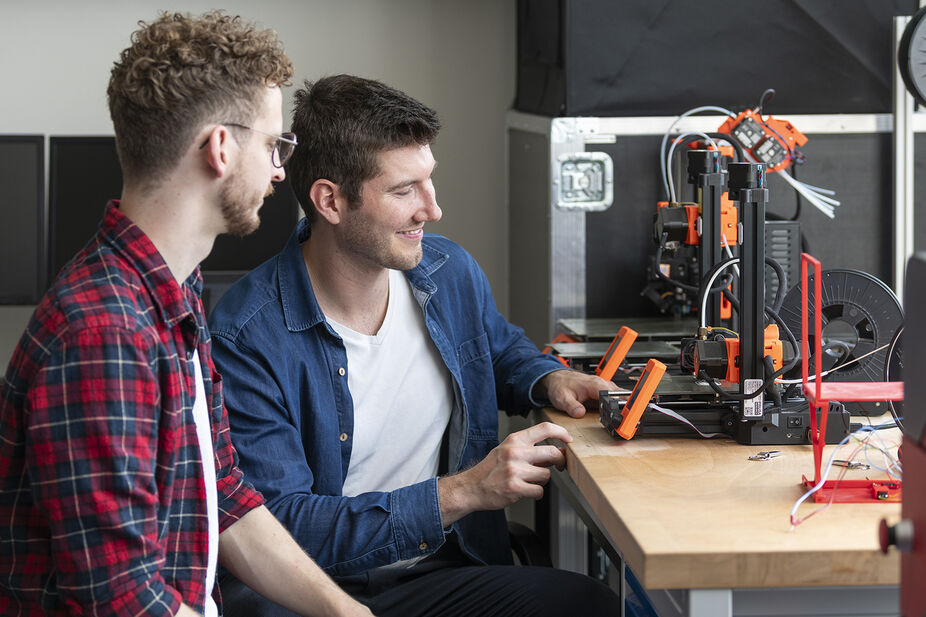 Praxisorientiertes Studium mit modernster Technik an der TH Lübeck Studierende der TH Lübeck arbeiten gemeinsam an einem 3D-Drucker im Praxislabor