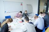 7 Personen arbeiten an einem Tisch