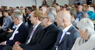 Das Publikum hört einem Redner zu.