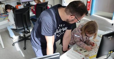 Eine Schülerin baut ein kleines Solarholzhaus auf. 