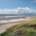 welliges Meer trifft auf Sandstrand