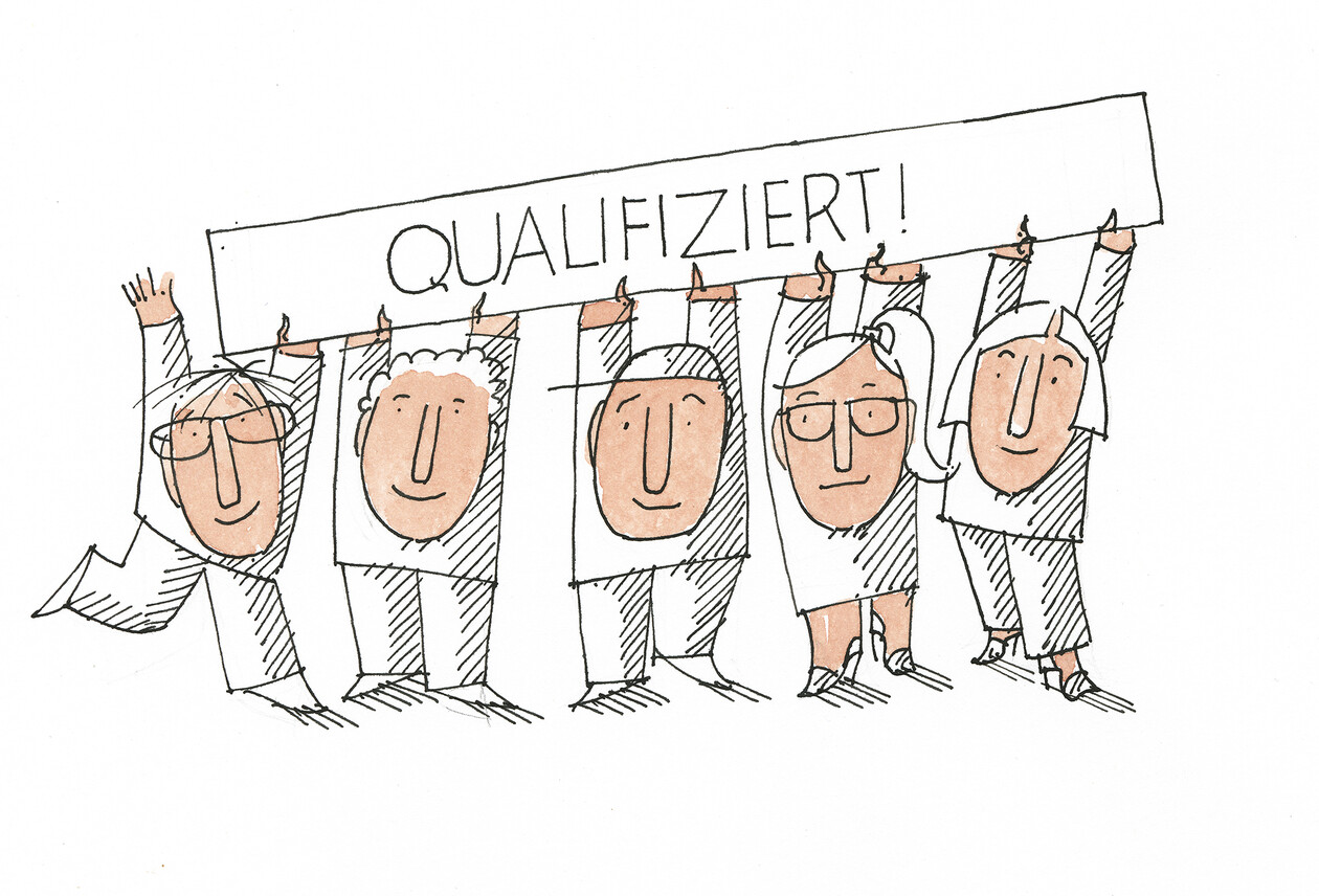Gruppe hält Banner mit Aufschrift „QUALIFIZIERT!“