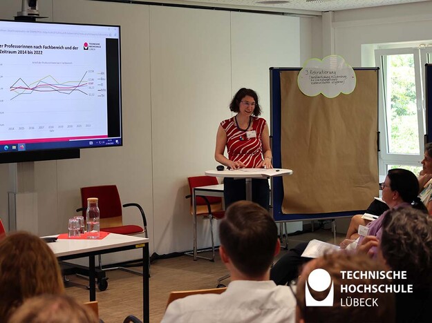 Präsentation der Gleichstellungsbeauftragten der TH Lübeck Person steht an einem Stehttisch und präsentiert etwas
