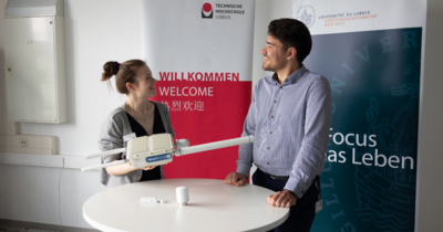 zwei Menschen vor Bannern 