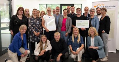 MINT-Schulen-Akkreditierung_3 Eine große Gruppe von Menschen lächelt in die Kamera.