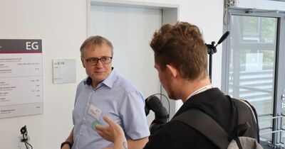 Ein Professor im Gespräch mit einem Studieninteressierten.