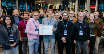 Eine Gruppe von Menschen schaut mit einem Zertifikat glücklich in die Kamera