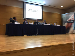 Four speakers at a panel discussion on a conference stage.