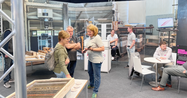 Menschen informieren sich beim Stand über Materialien 