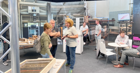 Menschen informieren sich beim Stand über Materialien 