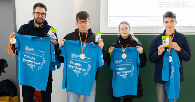 Auf dem Bild sieht man vier Personen mit blauen T-Shirts vor sich