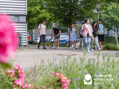 Studierende laufen an einem Gebäude vorbei