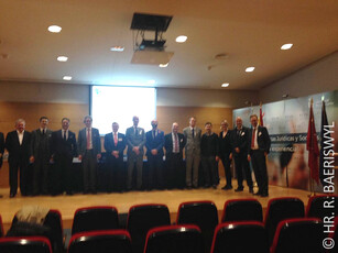 A large group of conference attendees posing for a photo on a stage.