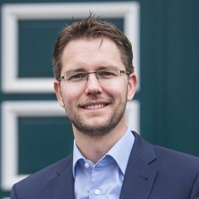 Foto von einem Mann vor einer dunkelgrünen Tür