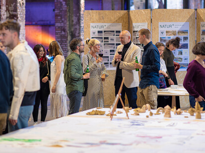 Gespräche mit Studierenden Bild zeigt Gäste die sich unterhalten und vor Ausstellungen stehen