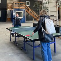 Zwei Personen spielen an einer Tischtennisplatte