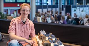 Ein Student kniet neben seinem Modell, dass einen Teil von Damaskus zeigt.