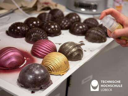 Thema weihnachtliches Essen Bild zeigt selbstgemachte Schokoladenmuscheln die besprüht werden