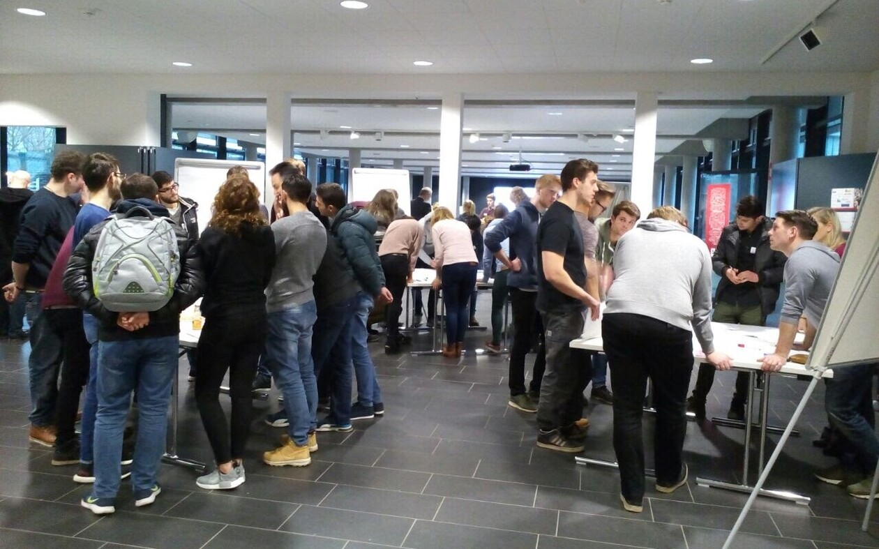 Workshop-Situation: Studierende diskutieren in Gruppen an Stehtischen.