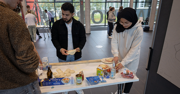 Pizza formen und belegen Studierende sind dabei Pizza zu formen und zu belegen