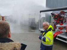 Ein Mitarbeiter von Minimax im rechten Bildausschnitt, hinter ihm eine große Wasserkanone
