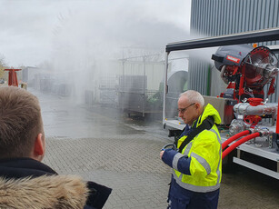 Ein Mitarbeiter von Minimax im rechten Bildausschnitt, hinter ihm eine große Wasserkanone