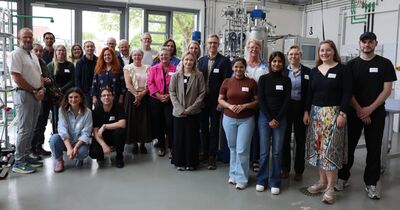 Gruppenfoto im Labor mit großen Fenstern im Hintergrund