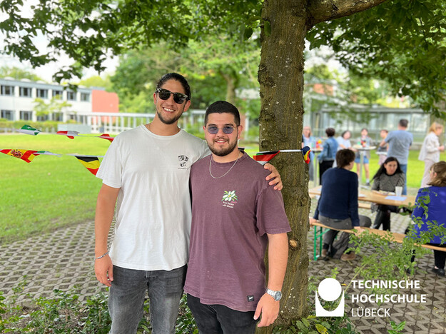 Zwei im grünen stehenden Studenten Arm in Arm