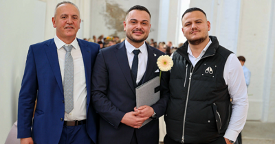 Absolvent mit Familie bei Graduierungsfeier der TH Lübeck, Blume am Revers