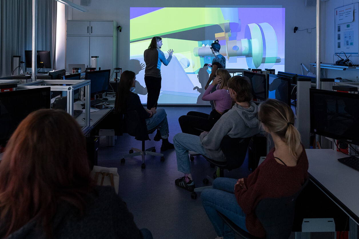Student mit AR Brille und Studierende die das Bild ebenfalls sehen können