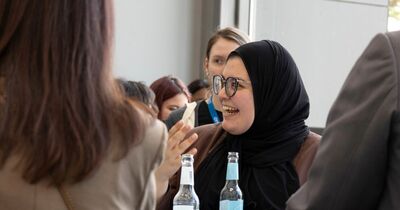 Eine junge mit einem Kopftuch lacht. 
