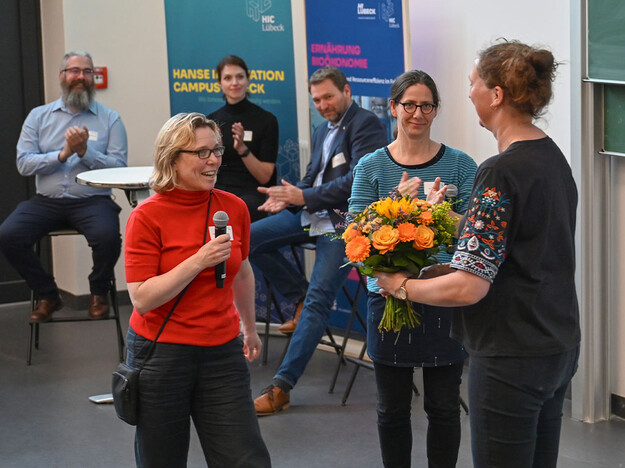 Blumenstraußübergabe an Organisatorin TH Lübeck Mitarbeitende überreichen Blumenstrauß an Organisatorin der Veranstaltung