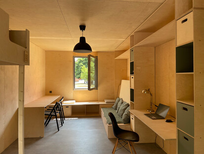 Innenansicht der Wohnunterkunft für Flüchtlinge Foto zeigt das Holzinterieur des Hauses mit Bett und Sitzmöglichkeiten