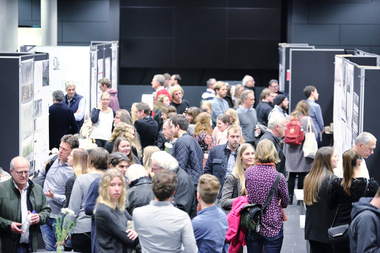 Blick in die Ausstellungshalle: Besucher zwischen Reihen von Stellwänden.