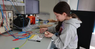 Eine Schülerin baut eine Solarwindmühle auf.