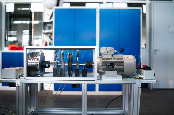 Technischer Prüfstand mit Elektromotor und Schwungrad.