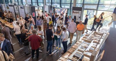 Viele Menschen stehen im Bauforum und schauen sich die Ausstellung an.