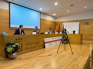 Three men at a panel discussion at the Universidad Rey Juan Carlos.