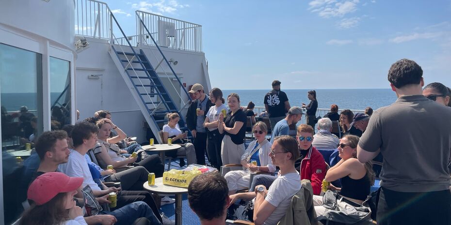 Zirka 30 Personen sitzen auf einem Boot und genießen die Atmosphäre