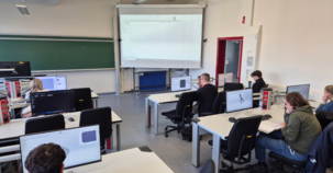 Studierende arbeiten in einem Computerraum an Bildschirmen mit 3D-Software.