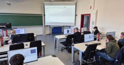 Studierende arbeiten in einem Computerraum an Bildschirmen mit 3D-Software.