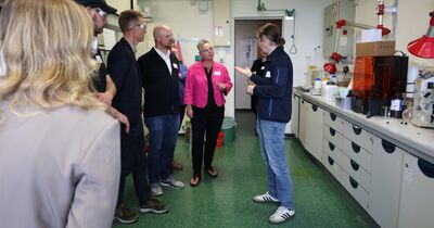 In einem Chemie-Labor spricht ein Mann vor einer kleinen Gruppe.