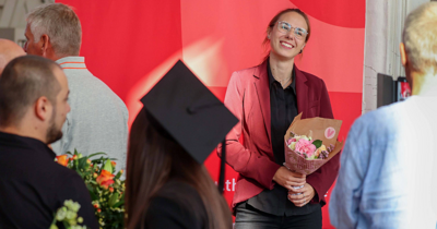 Gratulation bei Graduierungsfeier der TH Lübeck, Frau mit Blumenstrauß
