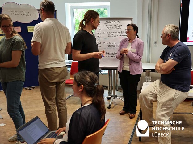 Brainstorming zum Thema Gleichstellung Mehrere Personen befinden sich in einem Raum und unterhalten sich