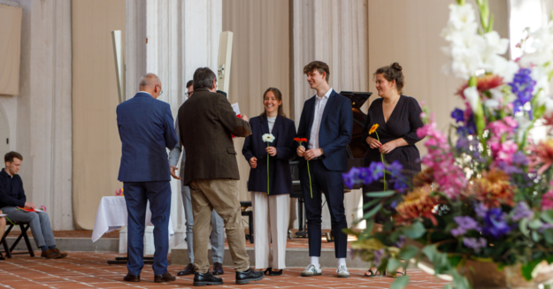 Blumenübergabe bei feierlichem Anlass. Übergabe von Blumen bei Veranstaltung.
