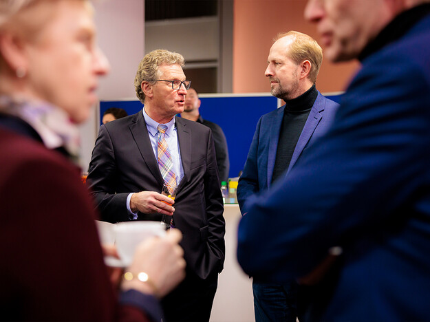 Besuch des ehemaligen Wirtschaftsministers vier männer, zwei im Hintergrund, zwei im Vordergrund