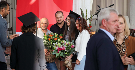 Familiengratulation bei TH Lübeck Graduierungsfeier, Absolventin mit Blumen
