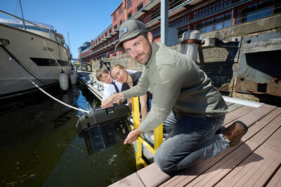 Drei Wissenschaftler lassen eine Sonde ins Wasser.