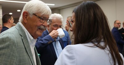 Ein Mann spricht auf einer Veranstaltung mit einer Frau.